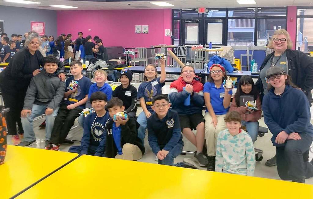 Murphree PK-8 robotics club smiles with robots