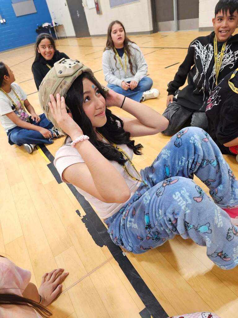 Murphree PK-8 student smiles as she tries on military gear