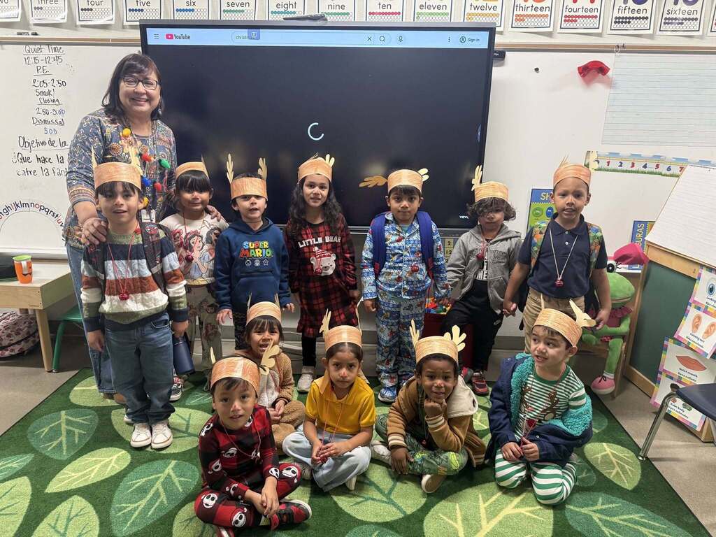 Murphree PK-8 students and teacher take a group photo with reindeer hats on