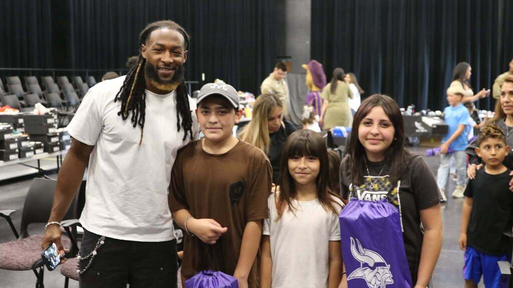 Aaron Jones takes photo with three kids after they received their new shoes