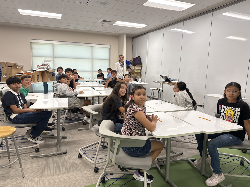 Haskins PK-8 students smile for a photo with teacher while in a classroom