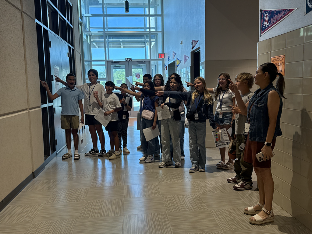 Haskins PK-8 students smile while pointing at door