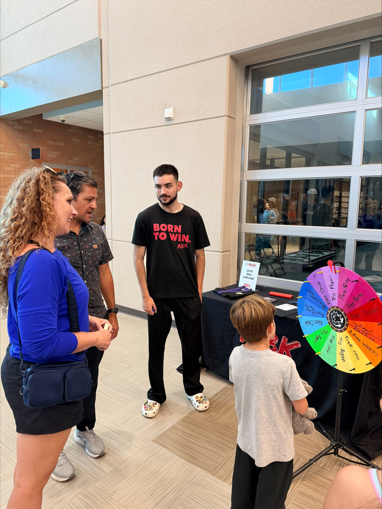 Family talking with teacher during open house night 
