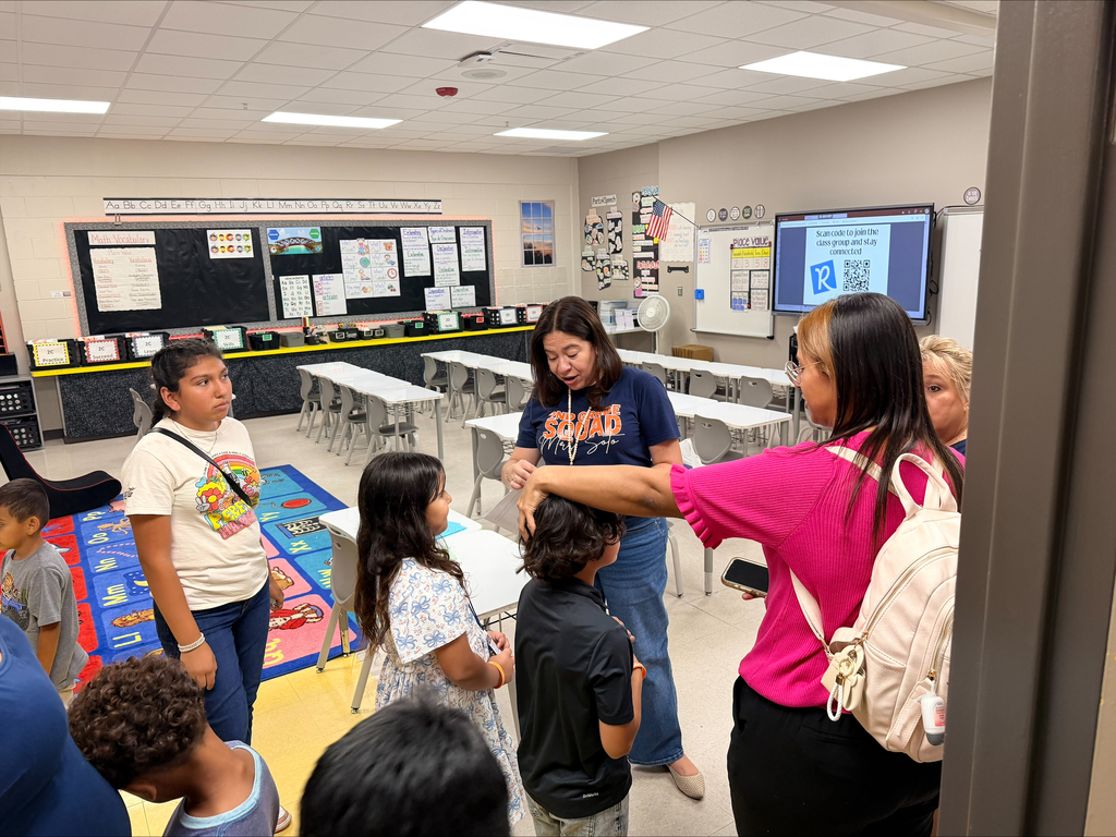 Family talking with teacher during open house night 