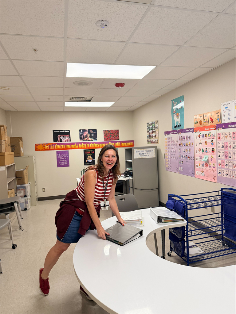 Teacher smiles for a photo while preparing for open house