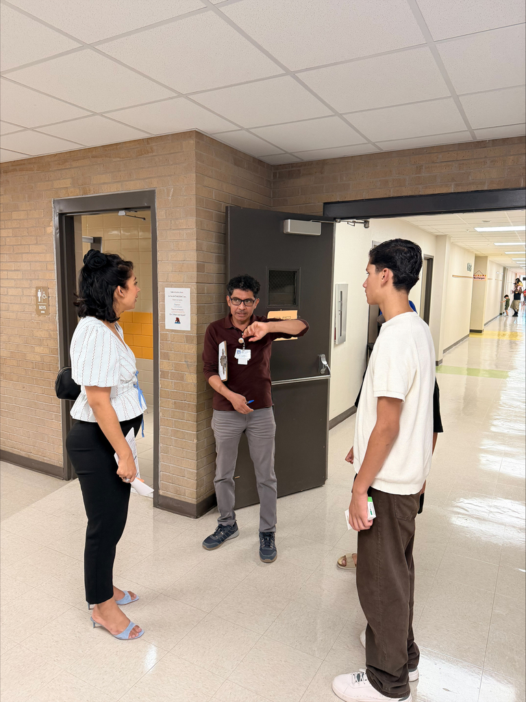 Family talking with teacher during open house night 