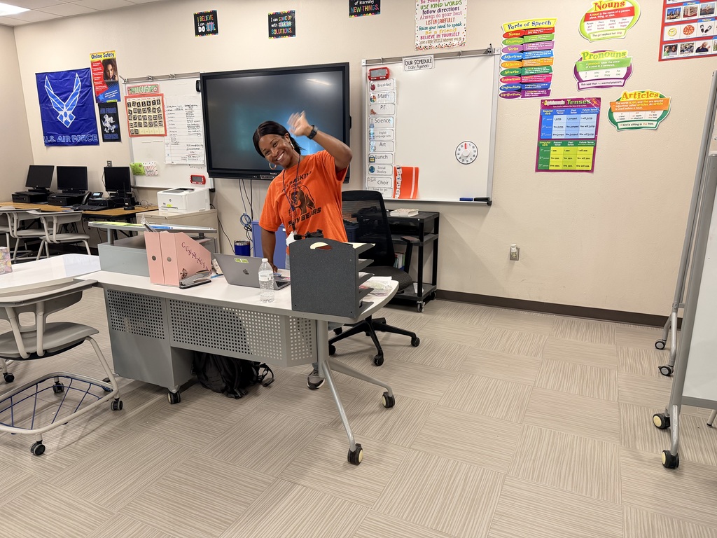 Teacher smiles for a photo while preparing for open house