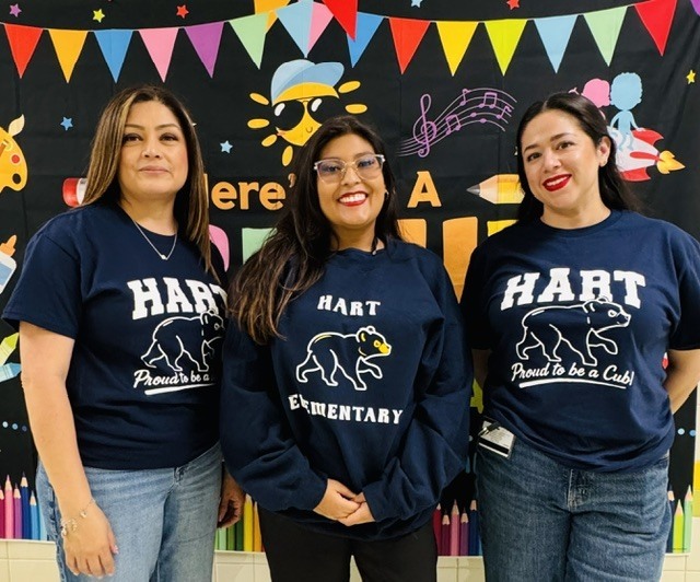Four women in matching blue sweatshirts, standing together. Each has "Hart Elementary" on the front.
