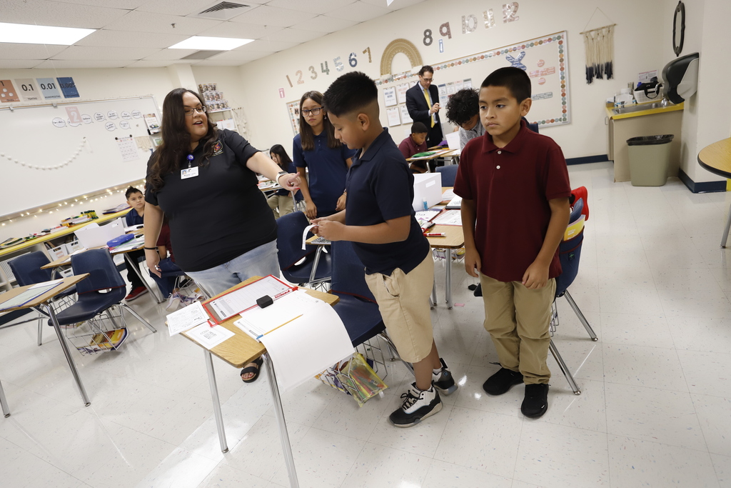 Moye Elementary teacher helps group of students during class