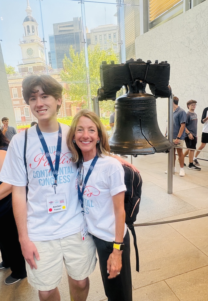 Ascher Vicini and Kristen Shaver posing in front of historic bell