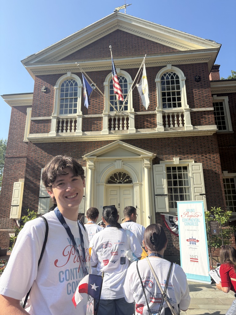 Ascher Vicini smiles in front of building