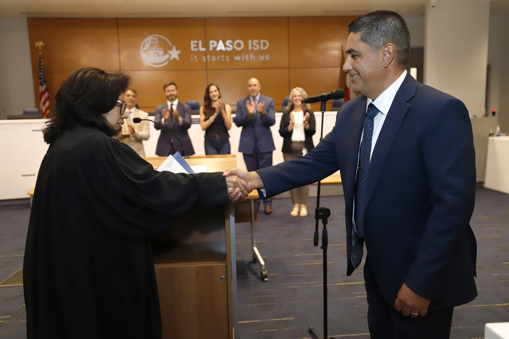 Photo of trustee member shaking hands after being sworn in