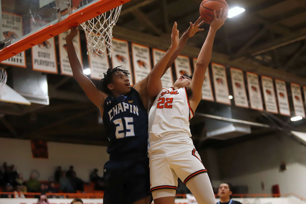 Chapin and El Paso High basketball players jump high into the air as the Tigers try to score and the Huskies try to block