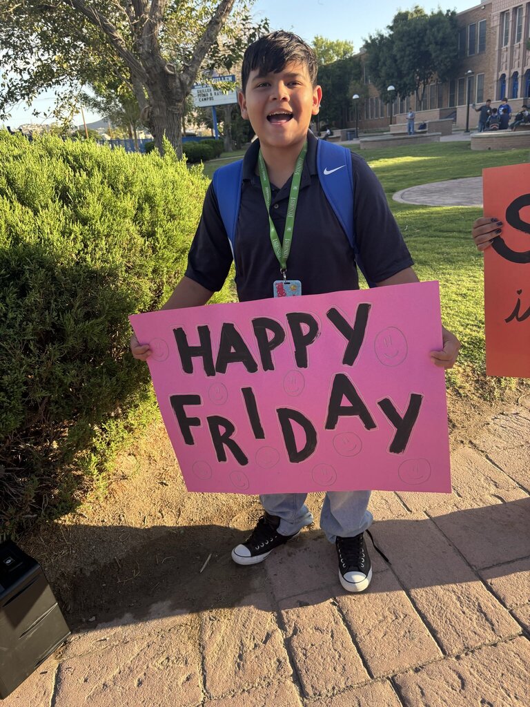 Guillen Middle School student holding up sign that says Happy Friday