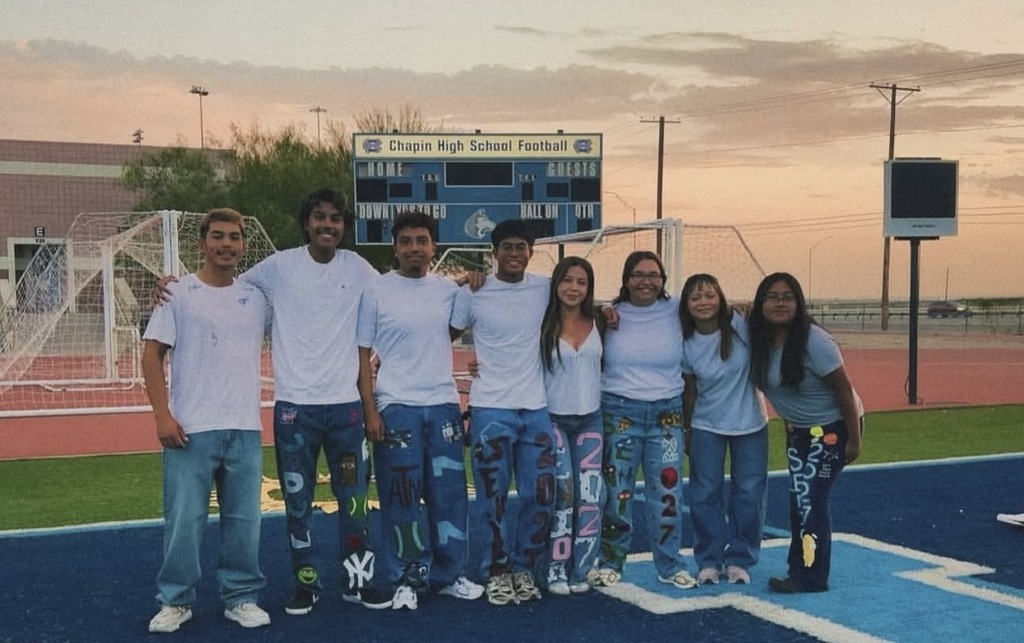 Chapin High School seniors take group photo on campus field during senior sunrise