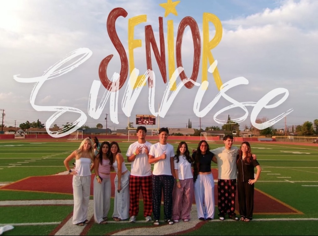 Andress High School seniors take group photo on school football field for senior sunrise and text on photo says senior sunrise