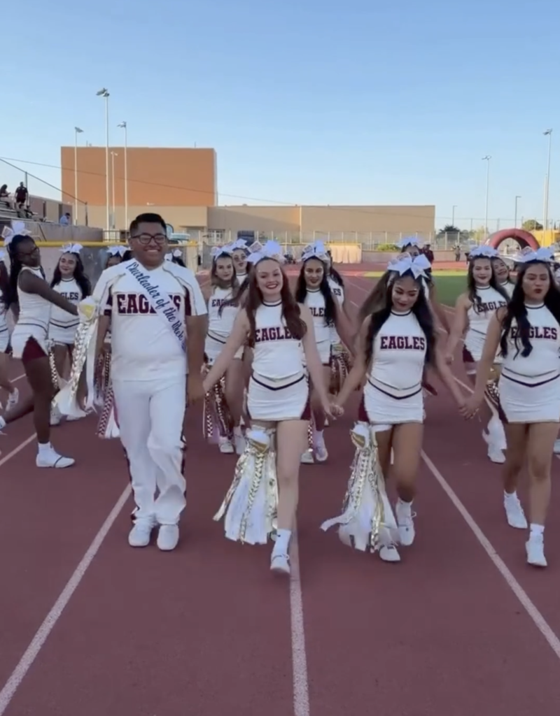 Andress High School cheer walking towards camera smiling