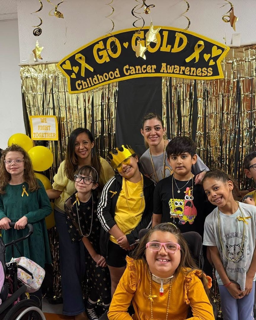 Students and staff smile for a photo dressed in gold for Childhood Cancer Awareness Month