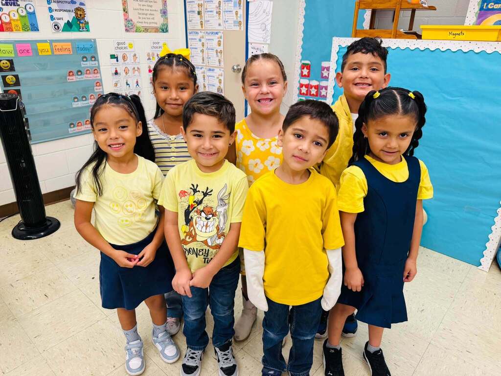 Students smile for a photo dressed in gold for Childhood Cancer Awareness Month