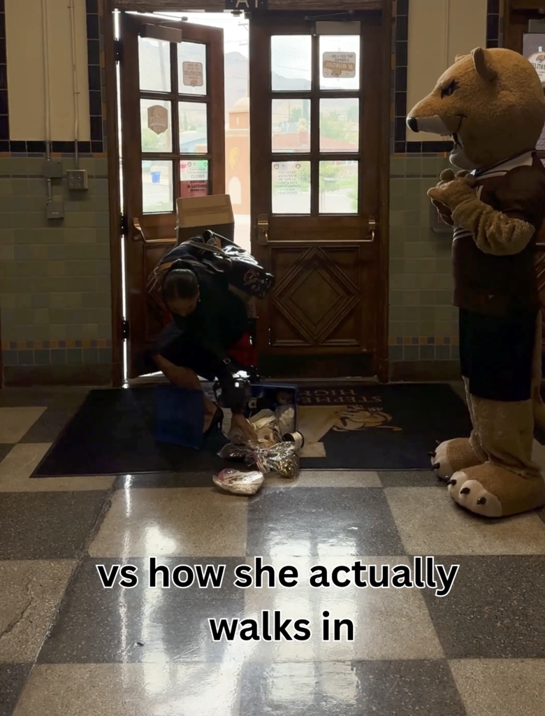 Austin High School principal walks into campus with lots of items in hand while picking up items she dropped on the floor with text on video that says vs how she actually walks in