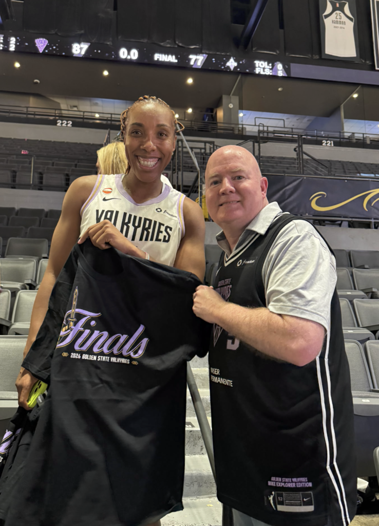 Kayla Thornton and Principal Robert Stives take photo after semifinals game holding up finals jersey