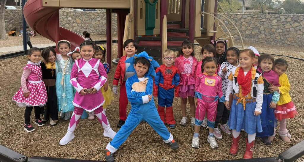 Students in Kohlberg Elementary playground take group photo dressed in halloween costumes