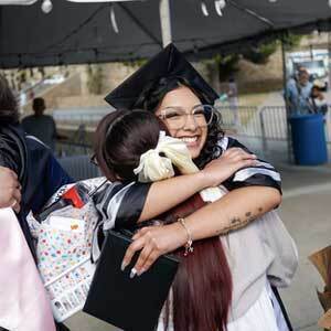 a graduate hugs a family member
