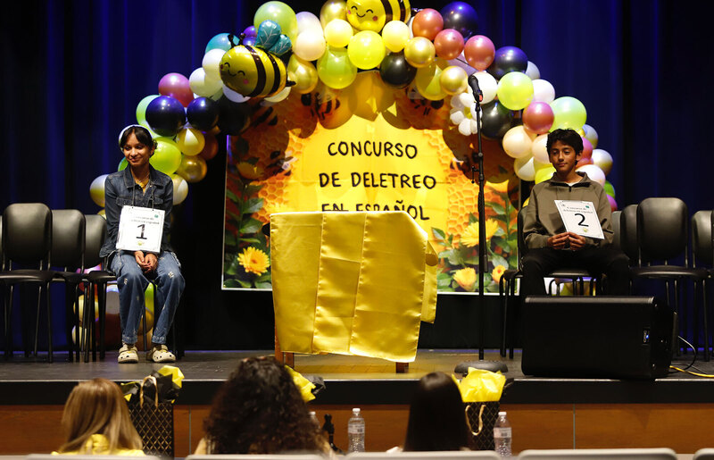 spelling bee competitors sit on stage