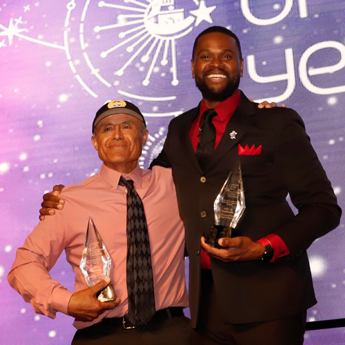two teacher of the. year winners pose with their awards