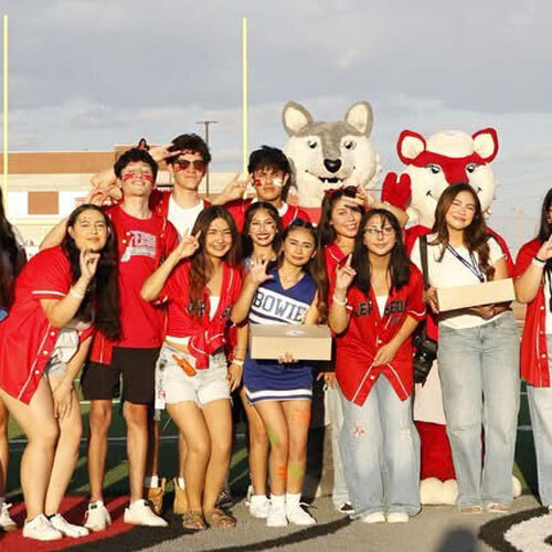 students pose at a football game