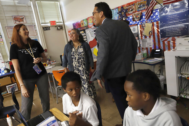 Students learn while a teacher speaks with administrators