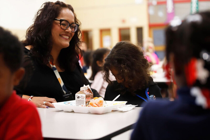 A teacher eats lunch with her students