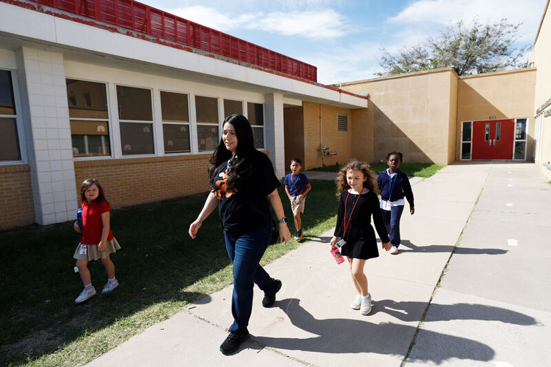 A teacher walks with her students