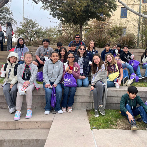 Students sit near a lawn