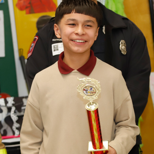 Student poses with a trophy