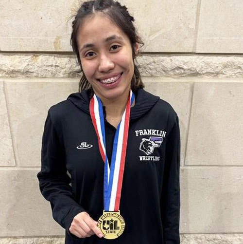A wrestler poses with her medal