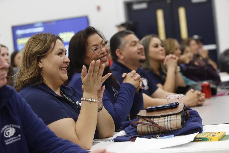 People sit around a table at a community meeting