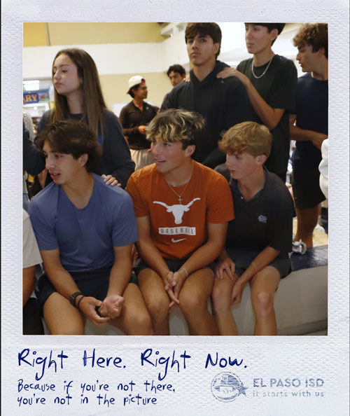 Two students chat at a table