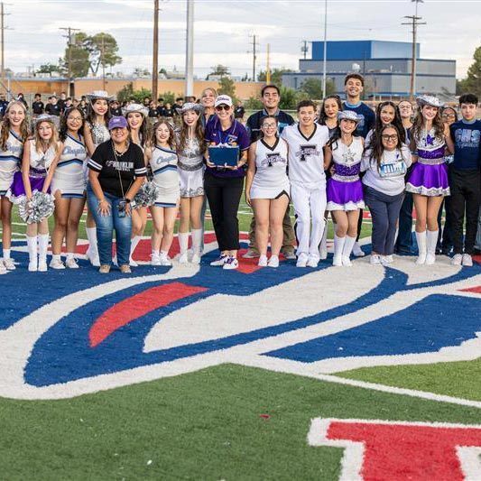 A group of students stand in a field