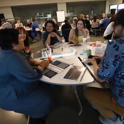 A group of stakeholders sit at a round table