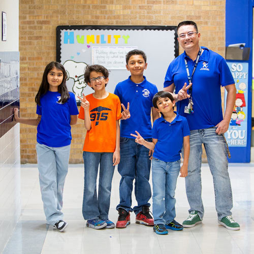 a group of students a parent stand in a hallway