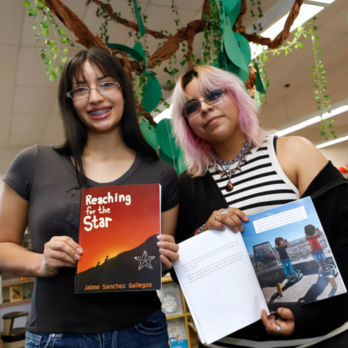 Students pose with a book