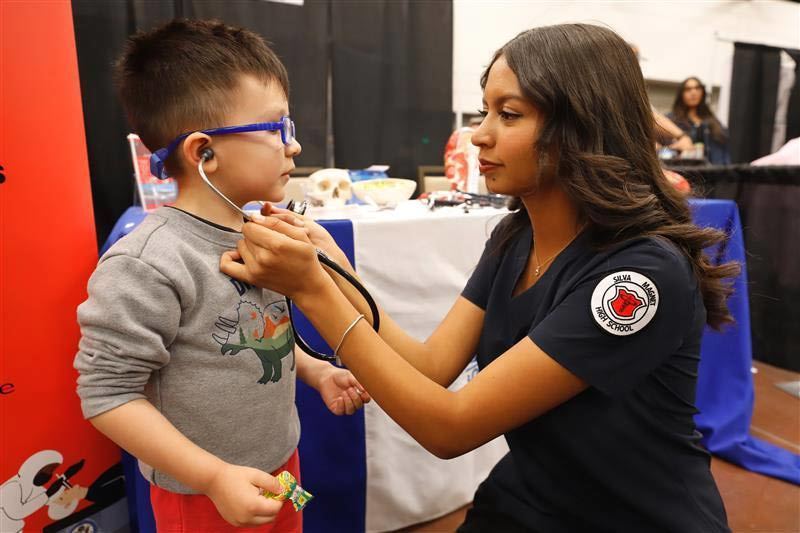 a student checks a child at the science festival