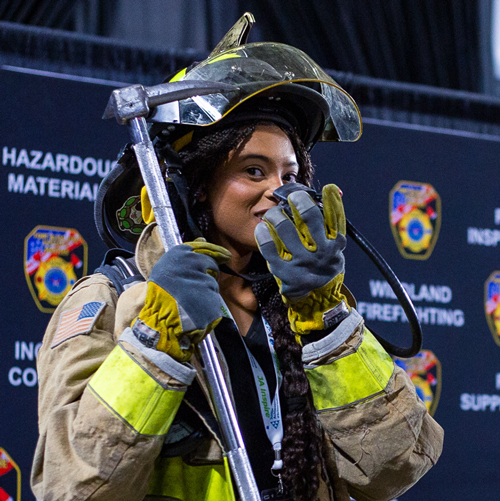 A student poses in a fire suit