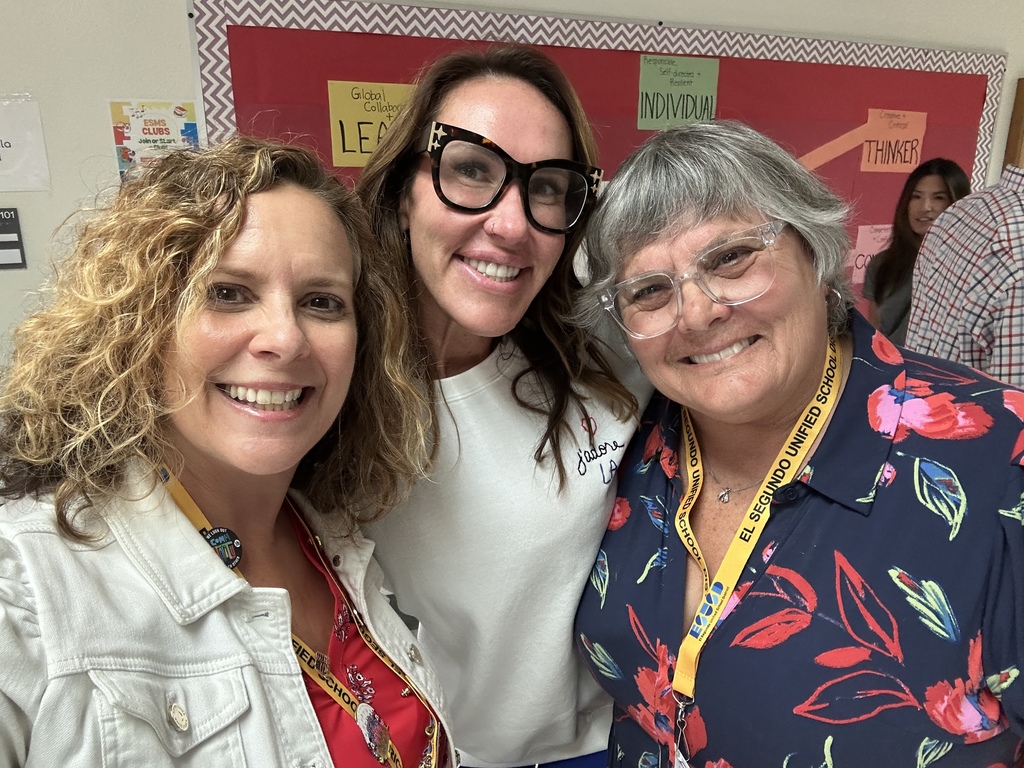Three women smile for a selfie indoors, wearing school lanyards with an El Segundo Unified School District badge visible.