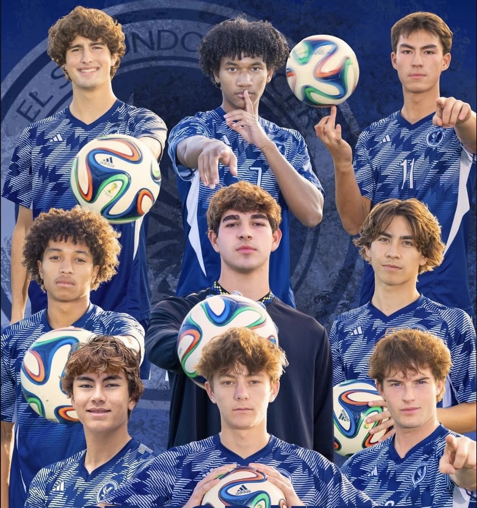 Group of young soccer players in blue patterned jerseys posing with colorful soccer balls against a dark background.