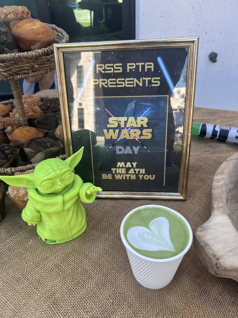 Star Wars–themed treat table with pastries, green latte art, and a sign reading “May the 4th Be With You.”