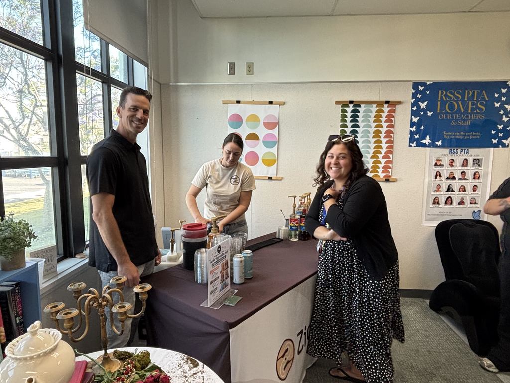 Coffee vendors smile behind a Ziggi’s Coffee station during a teacher appreciation event at Richmond Street School.