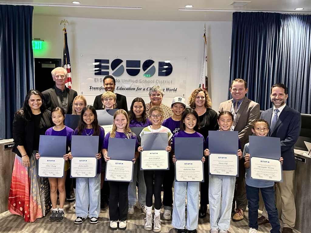Students proudly display recognition certificates alongside school board members and district leaders at an El Segundo Unified School District meeting.