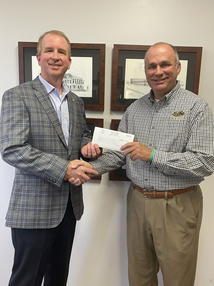 Two men standing in front of a backdrop.